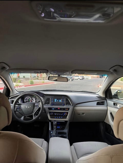 Interior view of a Hyundai vehicle with beige leather seats, steering wheel, and dashboard