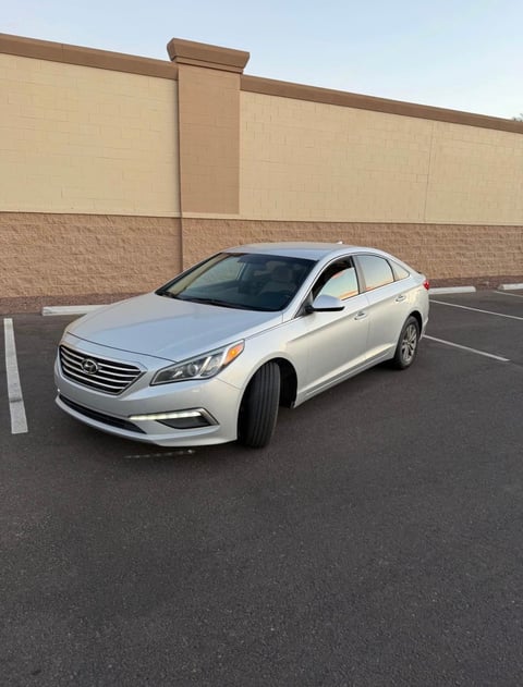 White Hyundai Sonata sedan parked in an empty parking lot