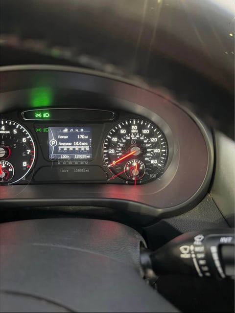 Car dashboard showing speedometer, digital display panel, and instrument gauges