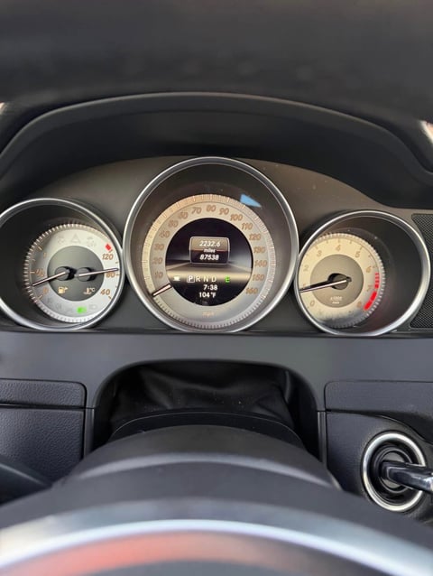 Close-up of a car analog dashboard with speedometer showing 67,000 miles